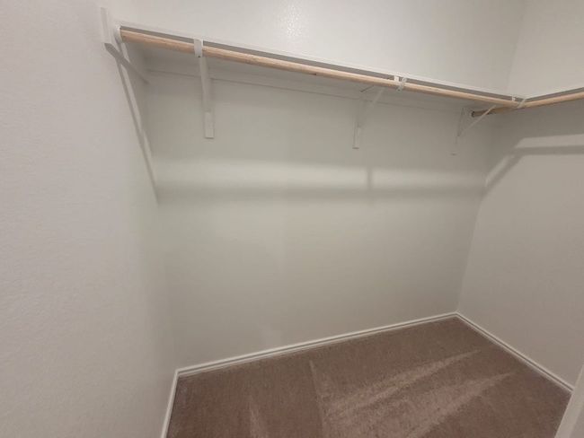 Spacious master's closet featuring dark colored carpet | Image 10