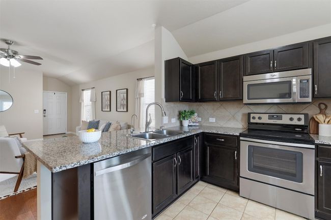 The breakfast bar gracefully connects the living space with the kitchen. | Image 10