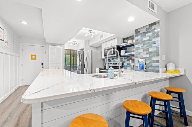 Kitchen featuring a peninsula, appliances with stainless steel finishes, light wood-style floors, a sink, and recessed lighting | Image 6