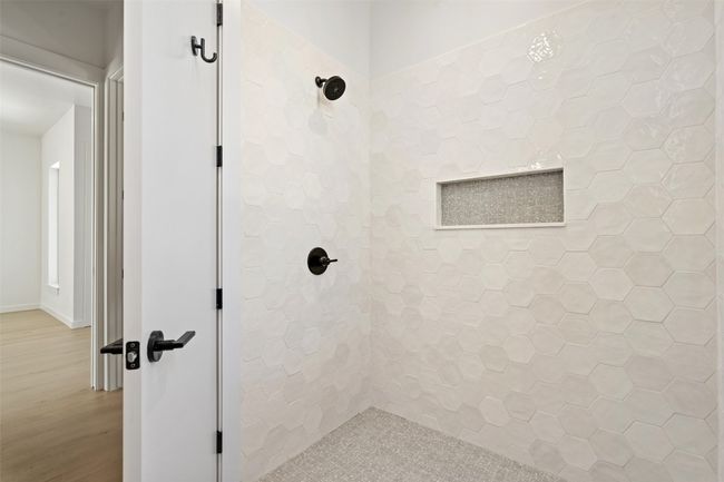 Bathroom featuring tiled shower and wood finished floors | Image 11