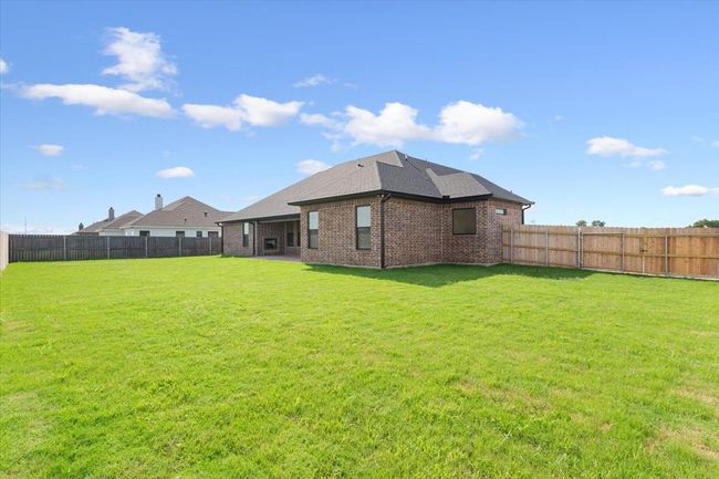 Rear view of house with brick siding, a fenced backyard, and a shingled roof | Image 38