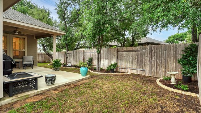 View of yard featuring a fenced backyard, a ceiling fan, a patio, and a fire pit | Image 28