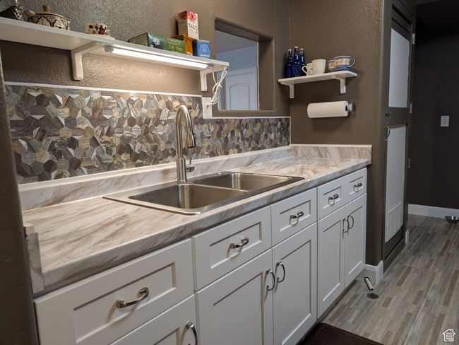 Kitchen featuring open shelves, light countertops, white cabinets, and a sink | Image 16