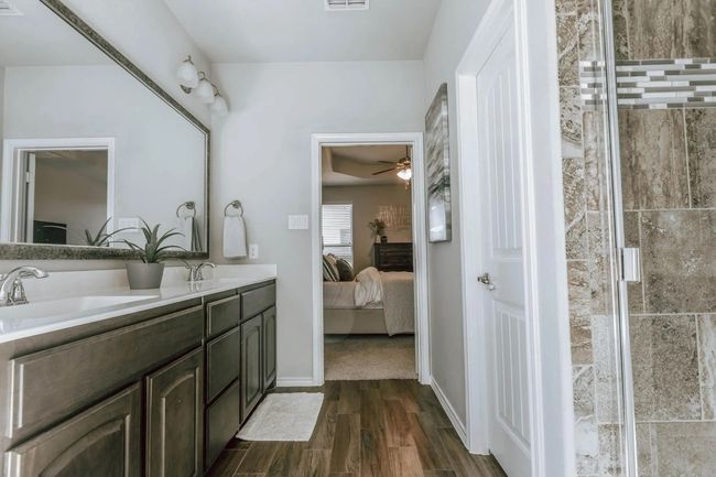 Bathroom with ensuite bath, visible vents, a sink, and wood finished floors | Image 27