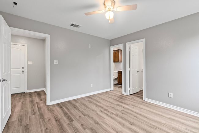 Primary bedroom featuring light wood finished floors, a ceiling fan, and ensuite bathroom | Image 13