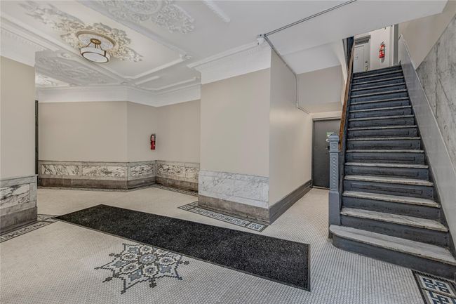 Lobby featuring stairs, a wainscoted wall, and crown molding | Image 6
