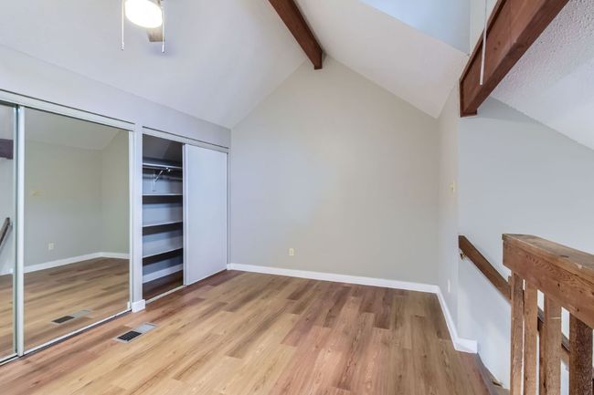 Unfurnished bedroom with vaulted ceiling with beams, light wood-style floors, visible vents, and baseboards | Image 18