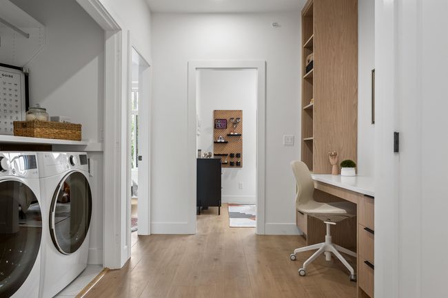 Washroom with separate washer and dryer, light wood finished floors, and a desk | Image 14