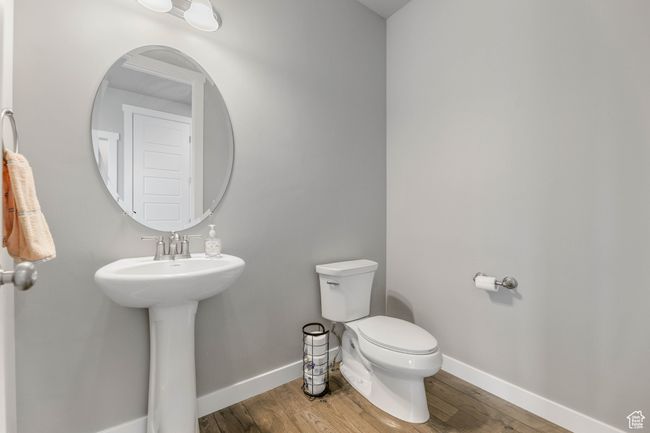 Bathroom with wood finished floors, toilet, baseboards, and a sink | Image 30