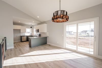 Kitchen featuring appliances with stainless steel finishes, white cabinets, plenty of natural light, and vaulted ceiling | Image 3