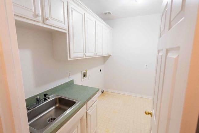 Washroom featuring hookup for a washing machine, cabinet space, and hookup for an electric dryer | Image 24