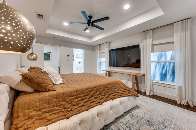 Bedroom featuring a tray ceiling, wood finished floors, baseboards, recessed lighting, and a ceiling fan | Image 25