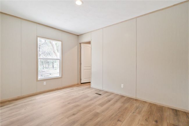 Spare room with visible vents, baseboards, and light wood-style floors | Image 16