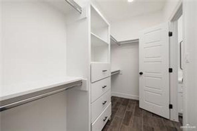 Spacious closet with dark wood-type flooring | Image 11