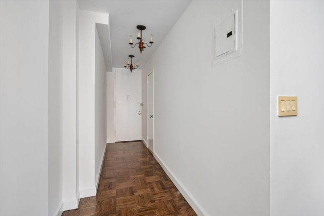 Hall featuring electric panel, a chandelier, and baseboards | Image 17
