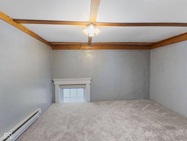 unfurnished room with a baseboard radiator, beamed ceiling, and carpet floors | Image 28