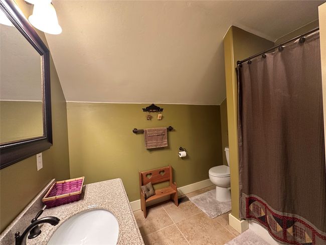 Bathroom featuring vanity, lofted ceiling, tile patterned floors, and curtained shower | Image 17
