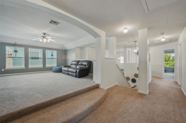 Living room featuring attic access, carpet flooring, baseboards, and ceiling fan | Image 25