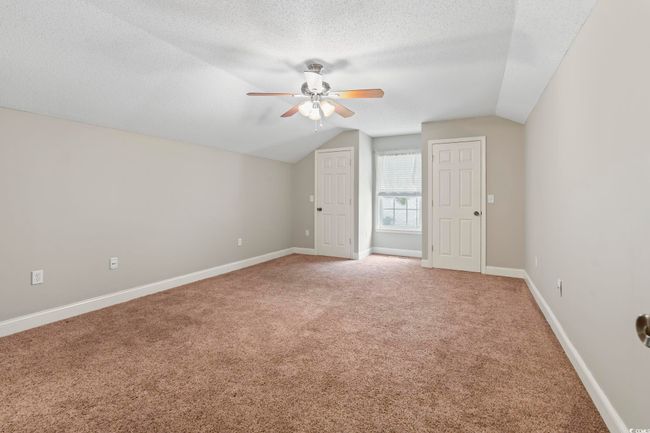 Bonus room with light carpet, ceiling fan, lofted ceiling, a textured ceiling, and baseboards | Image 26