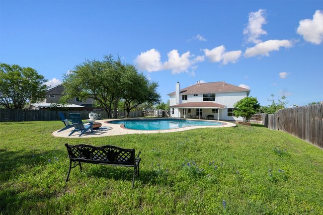View of swimming pool featuring a fenced backyard, a lawn, an outdoor fire pit, a patio area, and a fenced in pool | Image 31