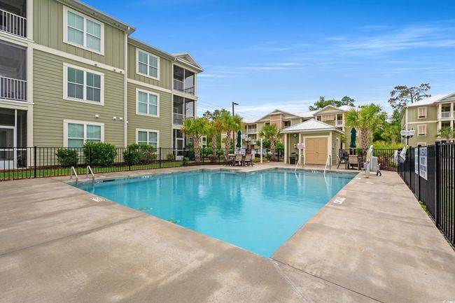 Community pool with fence and a patio | Image 22