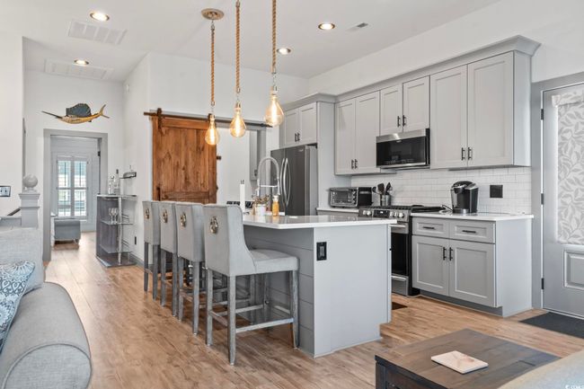 Kitchen featuring stainless steel appliances, light countertops, visible vents, and gray cabinets | Image 7