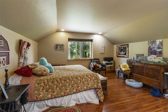 Bedroom featuring wood finished floors and lofted ceiling | Image 38