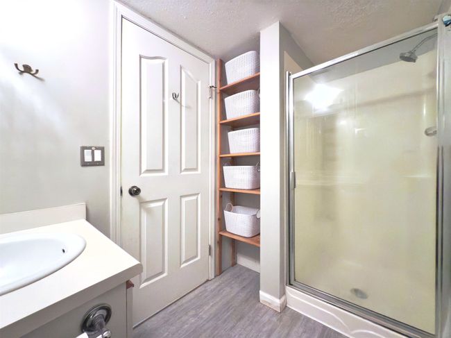 Full bath with wood finished floors, a stall shower, a textured ceiling, and vanity | Image 12