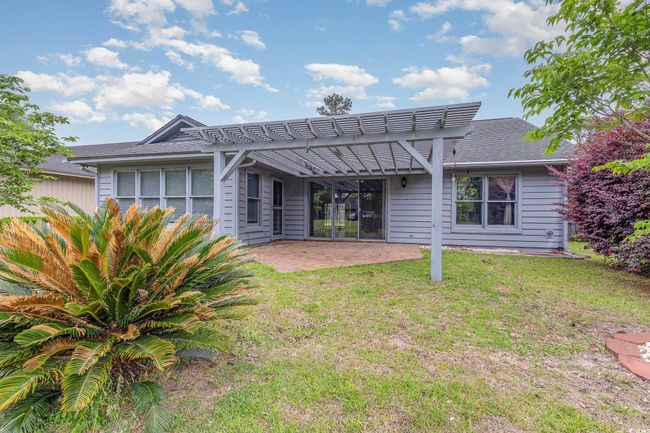 Rear view of property featuring a pergola, a shingled roof, a yard, and a patio | Image 29