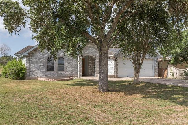 View of front of house featuring driveway, a garage, a front lawn, and brick siding | Image 22