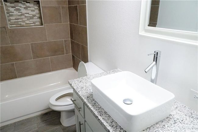 Bathroom featuring toilet, shower combination, vanity, and wood finished floors | Image 13