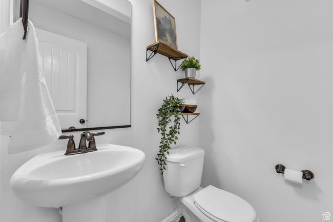 Bathroom featuring toilet, baseboards, and a sink | Image 13