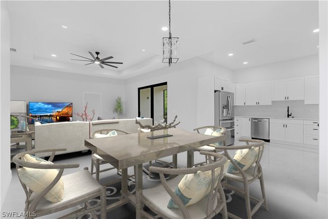 Dining room featuring ceiling fan, a tray ceiling, and sink | Image 49