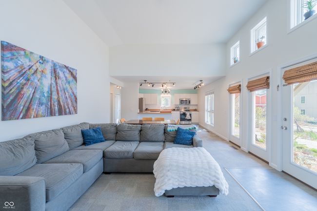 living area featuring track lighting, a towering ceiling, and a healthy amount of sunlight | Image 5