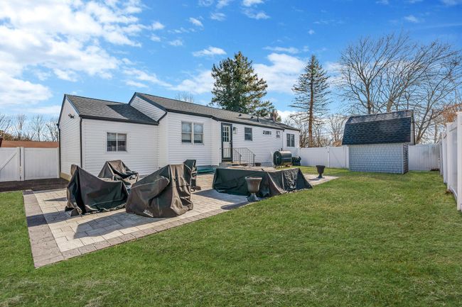 Rear view of property with a storage shed, a patio, and a lawn | Image 24