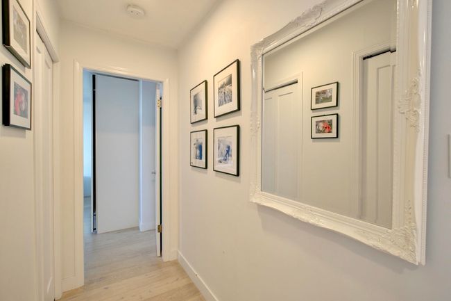 Hallway with light wood-style flooring and baseboards | Image 17
