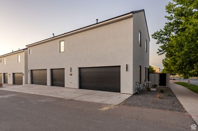 Property exterior at dusk with a garage and central air condition unit | Image 44