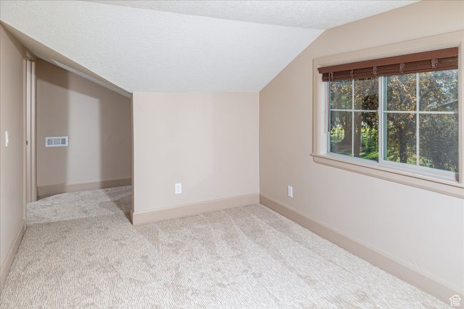 Bonus room featuring lofted ceiling, carpet floors, and a textured ceiling | Image 39