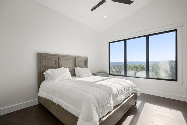 Main level bedroom/primary with angled ceilings and views of the hill country. | Image 10