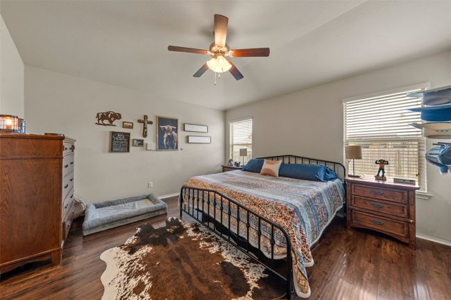 Bedroom with dark wood-style flooring and ceiling fan | Image 11