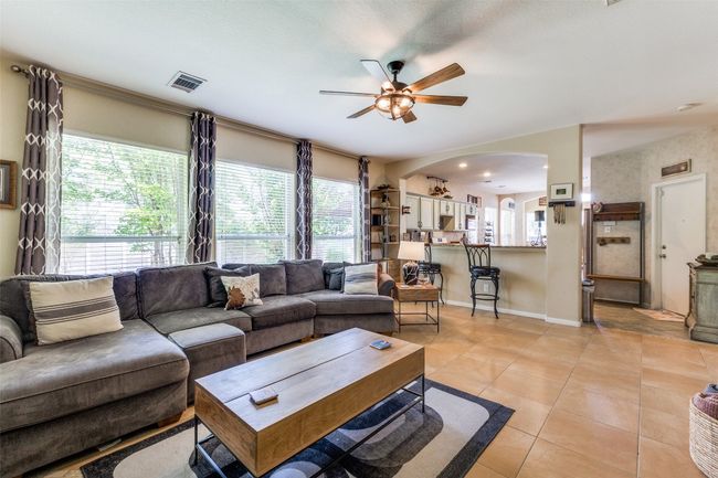 Living room featuring arched walkways, ceiling fan, and plenty of natural light | Image 6