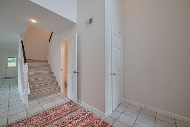 Bright and airy two-story foyer creates a stunning first impression with natural light pouring in and brand new vinyl flooring on the stairs adding a fresh, modern touch. | Image 5