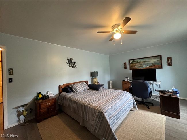 Bedroom featuring wood finished floors, baseboards, a ceiling fan, and a desk | Image 18