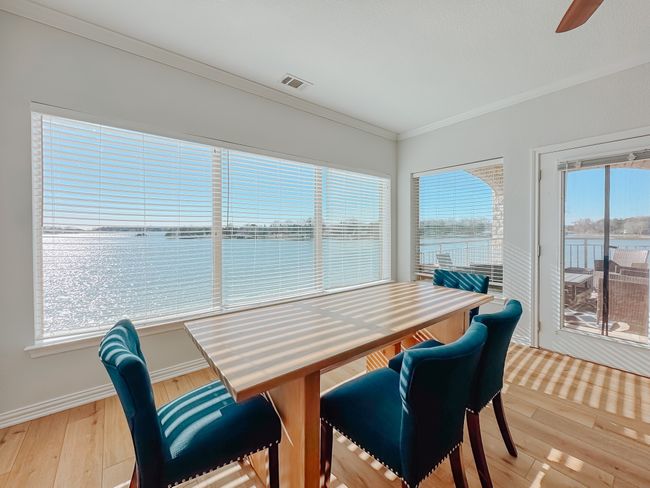 Dining room featuring a water view, wood finished floors, visible vents, baseboards, and crown molding | Image 7