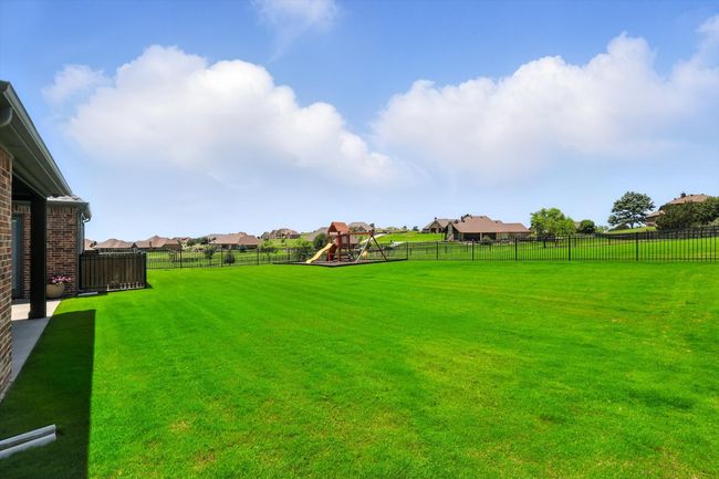 Fenced backyard featuring a playground and a residential view | Image 37