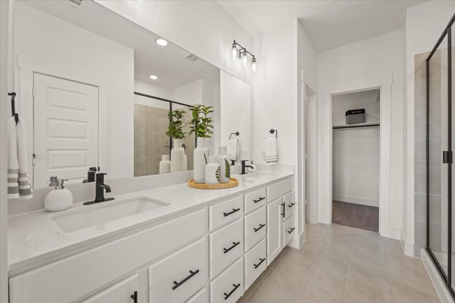 Ensuite bathroom featuring a shower stall, double vanity, tile patterned flooring, and recessed lighting | Image 7
