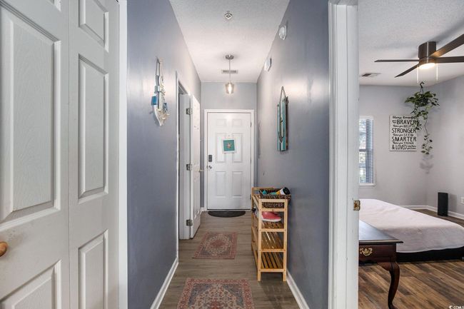 Hallway featuring wood finished floors, baseboards, and a textured ceiling | Image 12