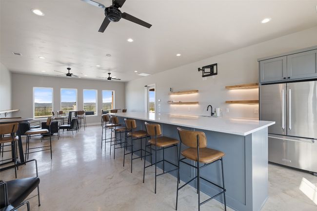Kitchen with high quality fridge, ceiling fan, concrete floors, recessed lighting, and open shelves | Image 25