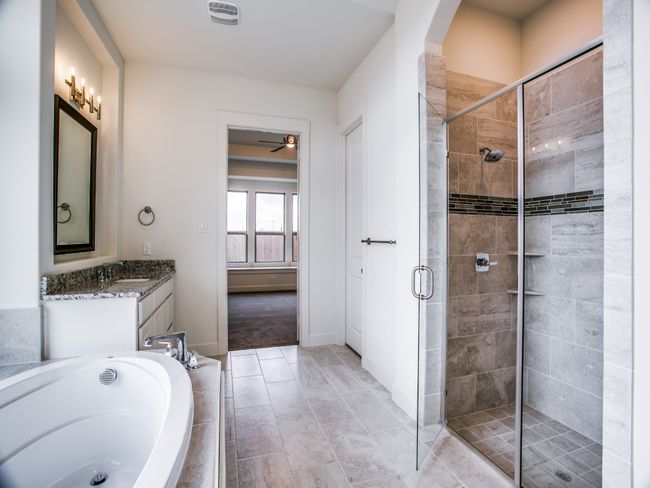 Full bathroom featuring a stall shower, a bath, vanity, and a ceiling fan | Image 16