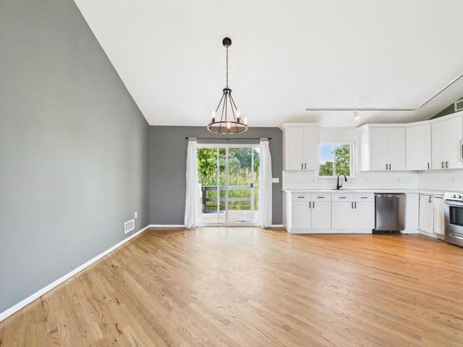 Kitchen featuring appliances with stainless steel finishes, a chandelier, light countertops, light wood-type flooring, and vaulted ceiling | Image 10
